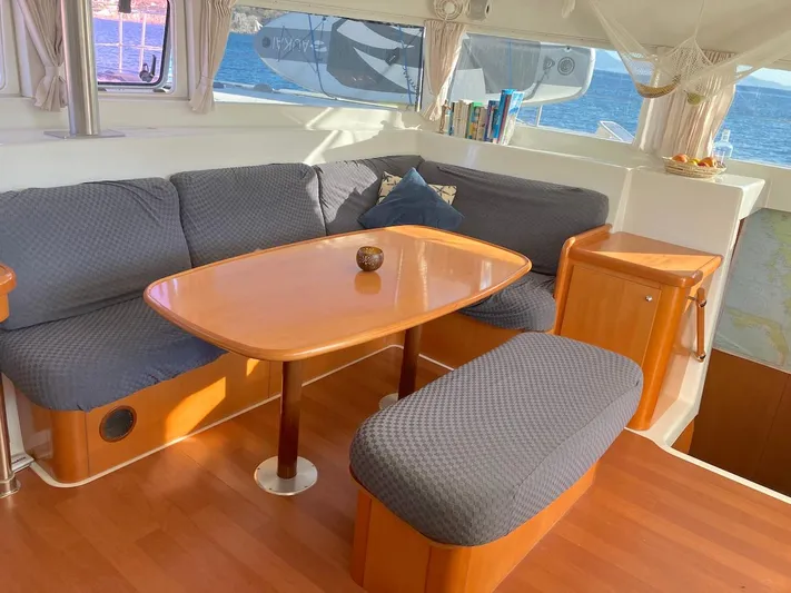 Kirlana Yacht Photos Pics Cozy interior of 2006 Lagoon 420 yacht with wooden table and cushioned seating.