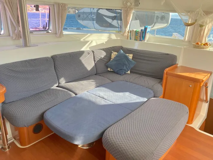Kirlana Yacht Photos Pics Cozy interior of 2006 Lagoon 420 catamaran with cushioned seating and wooden accents.