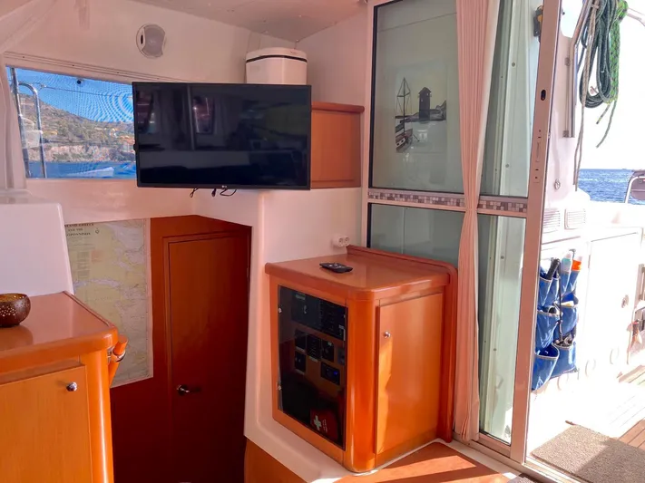 Kirlana Yacht Photos Pics Interior of 2006 Lagoon 420 yacht with TV, wooden cabinetry, and ocean view.