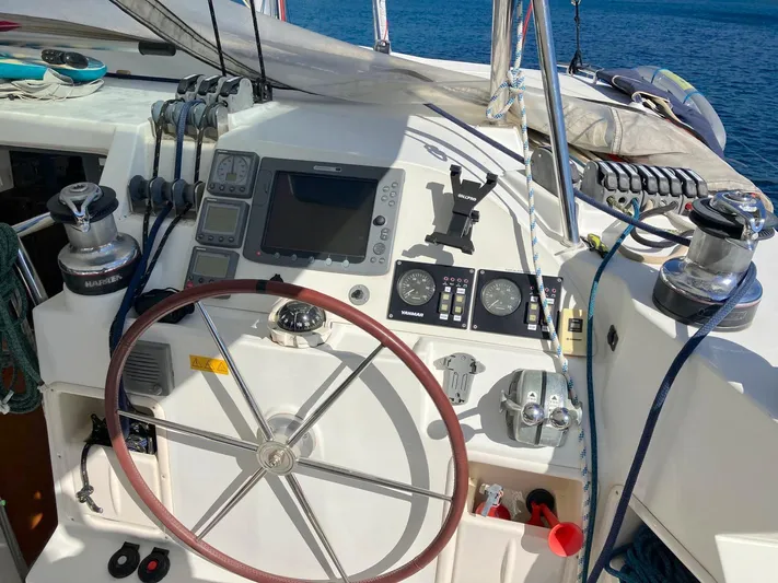 Kirlana Yacht Photos Pics Steering wheel and controls of a 2006 Lagoon 420 catamaran, with ocean backdrop.
