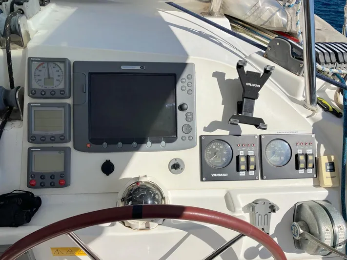 Kirlana Yacht Photos Pics Control panel of a 2006 Lagoon 420 yacht with navigation instruments and steering wheel.