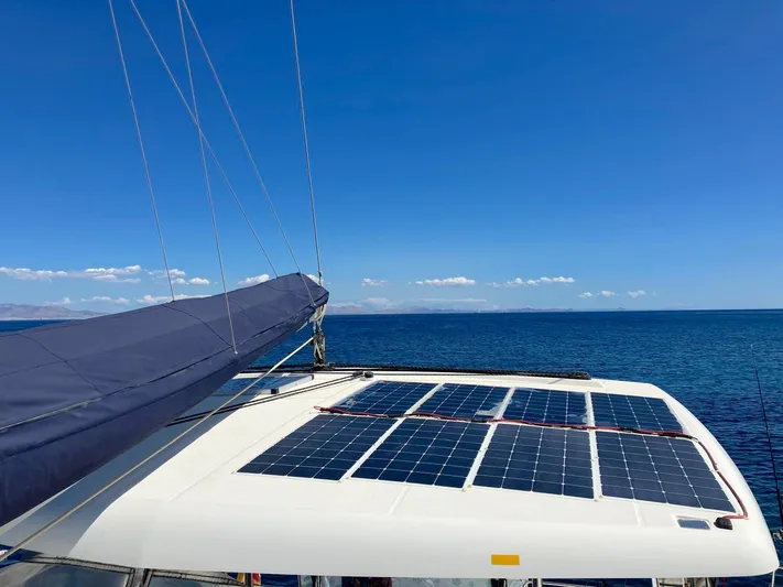 Kirlana Yacht Photos Pics Lagoon 420 catamaran with solar panels on deck, sailing under clear blue skies.