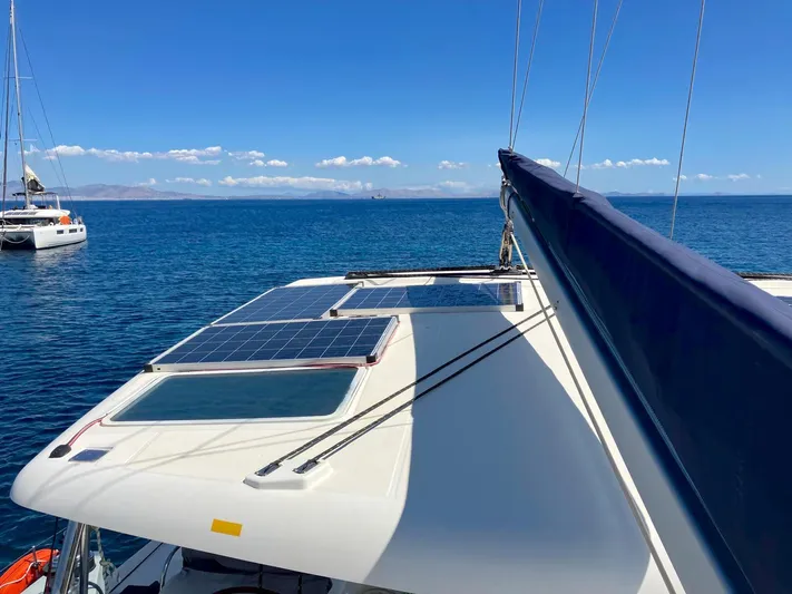 Kirlana Yacht Photos Pics Lagoon 420 catamaran with solar panels on deck, sailing in clear blue waters.