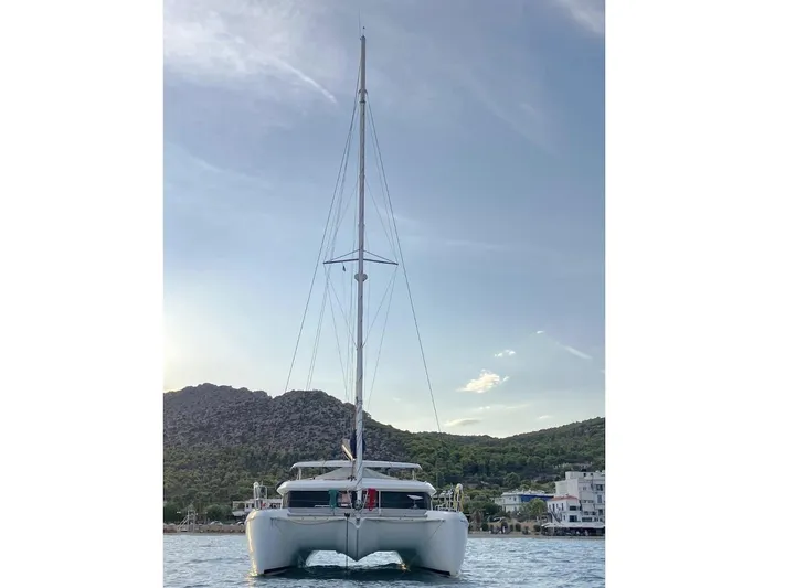 Kirlana Yacht Photos Pics 2006 Lagoon 420 catamaran on calm water with scenic mountain backdrop.