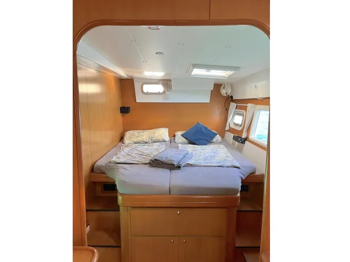 Kirlana Yacht Photos Pics Interior cabin of 2006 Lagoon 420 catamaran with cozy bed and wooden finish.