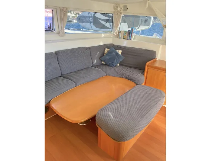 Kirlana Yacht Photos Pics Interior of 2006 Lagoon 420 yacht with cozy seating and wooden table.