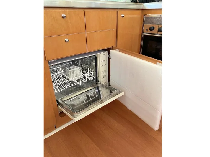 Kirlana Yacht Photos Pics Open dishwasher in wooden kitchen of 2006 Lagoon 420 yacht.