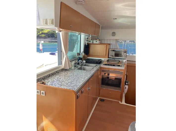 Kirlana Yacht Photos Pics Modern kitchen interior of 2006 Lagoon 420 yacht with wood cabinets and appliances.