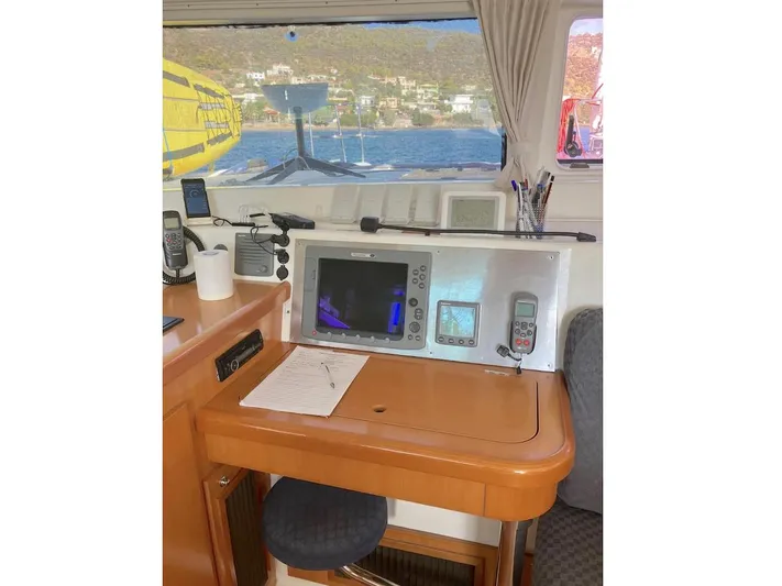 Kirlana Yacht Photos Pics Navigation station inside a 2006 Lagoon 420 catamaran with control panel and sea view.