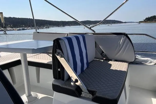  Yacht Photos Pics 2018 Jeanneau Velasco 37F yacht interior with seating and table, overlooking serene waters.