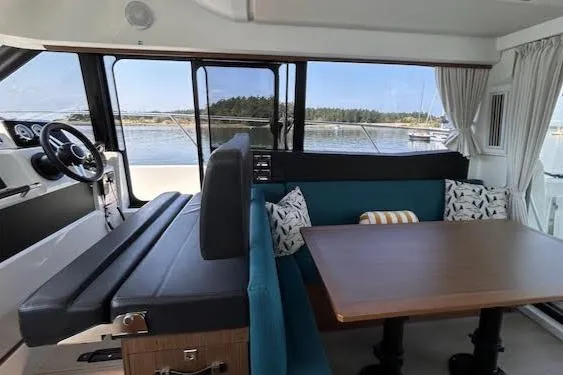  Yacht Photos Pics Interior of 2018 Jeanneau Velasco 37F yacht with seating and table, overlooking water.