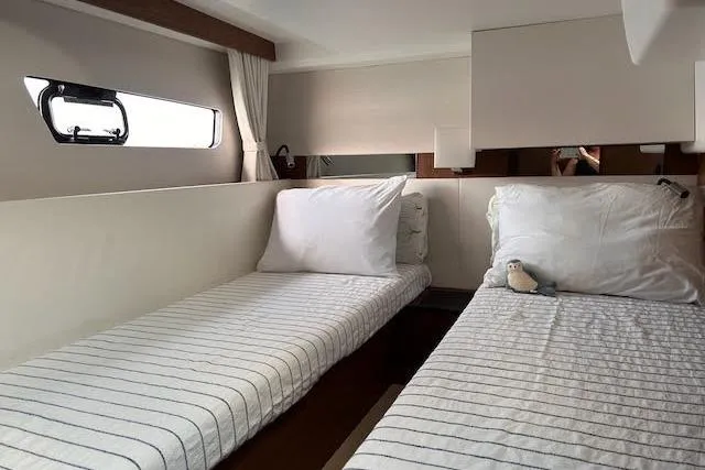  Yacht Photos Pics Interior cabin of 2018 Jeanneau Velasco 37F with twin beds and striped bedding.