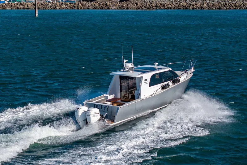  Yacht Photos Pics 2020 Coastal Craft 33 Express cruising on open water, showcasing sleek design and powerful engines.