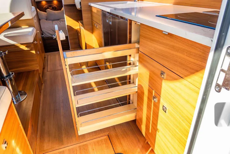  Yacht Photos Pics Interior of 2020 Coastal Craft 33 Express yacht with modern wooden cabinetry and pull-out storage.