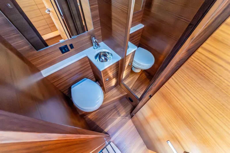  Yacht Photos Pics Luxurious bathroom interior of 2020 Coastal Craft 33 Express yacht, featuring wood finish and modern fixtures.