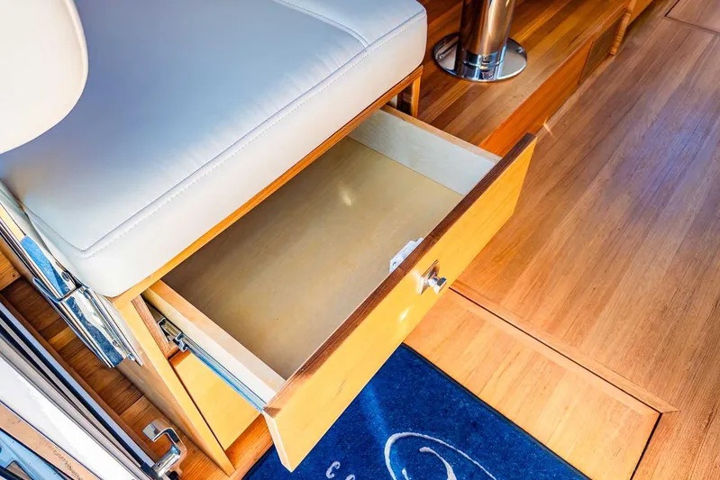  Yacht Photos Pics Open drawer in 2020 Coastal Craft 33 Express yacht interior, featuring wooden flooring and cushioned seating.