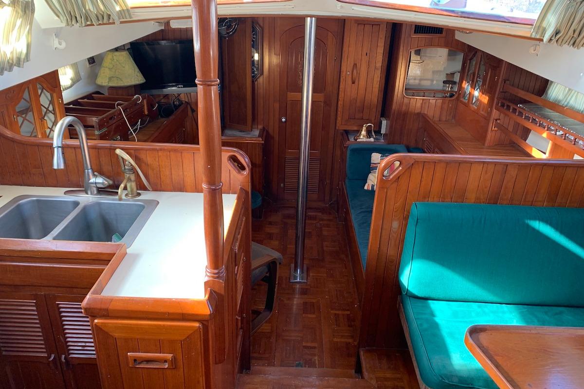 Interior of 1981 Hardin 45 sailboat with wood finish and teal seating.