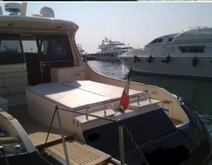  Yacht Photos Pics 2005 Mochi Craft 51 Dolphin yacht docked in marina, featuring spacious deck and Italian flag.