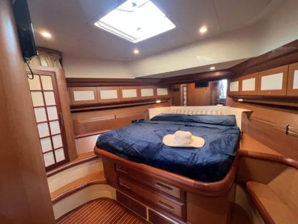  Yacht Photos Pics Luxurious cabin interior of 2005 Mochi Craft 51 Dolphin yacht with cozy bed and wooden accents.