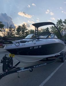 2021 Tahoe 550 TF boat on trailer at sunset, parked in a scenic area.