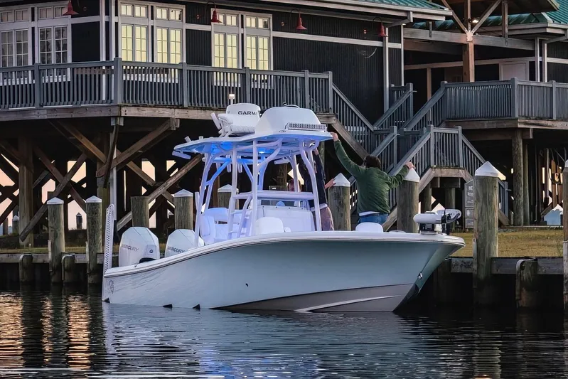  Yacht Photos Pics 2022 Barker Boatworks 26 Open docked near a wooden building.