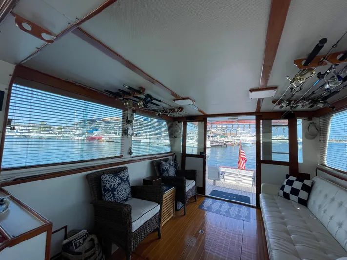Huck Fin Yacht Photos Pics Interior of a 1966 Huckins Sportsman boat with seating and fishing rods.