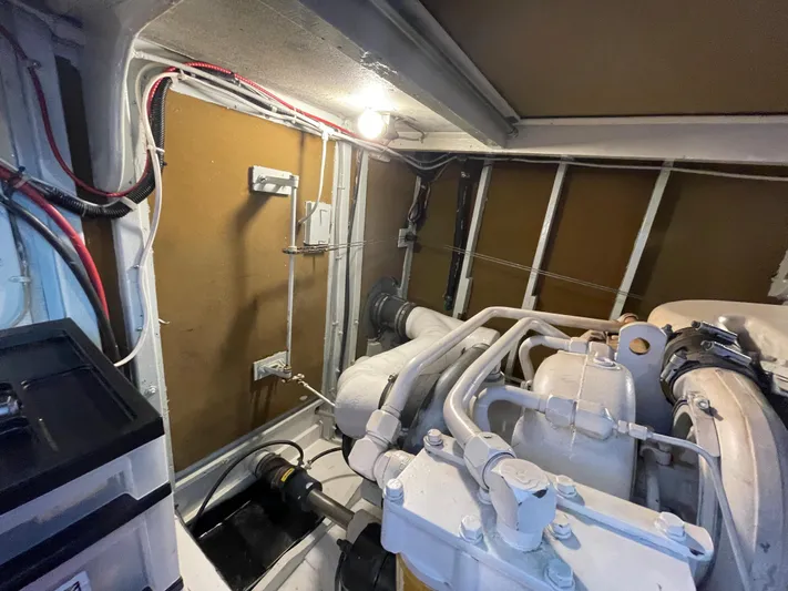 Huck Fin Yacht Photos Pics Engine room of a 1966 Huckins Sportsman boat, showcasing mechanical components and wiring.