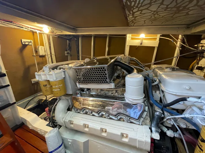 Huck Fin Yacht Photos Pics Engine room of a 1966 Huckins Sportsman boat, featuring a well-maintained engine.