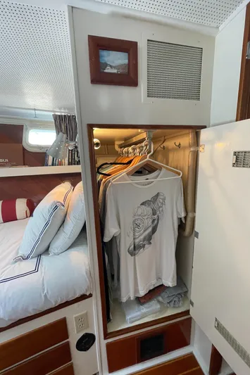 Huck Fin Yacht Photos Pics 1966 Huckins Sportsman cabin with closet, bed, and hanging clothes.