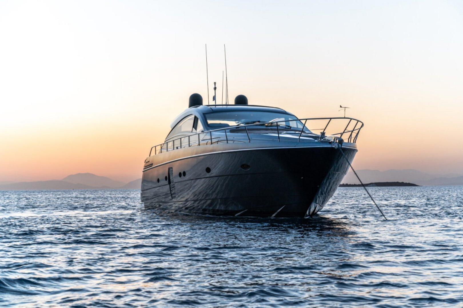 2008 Pershing 64' yacht anchored at sunset on calm waters.