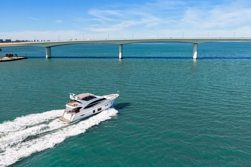 Fortunato Yacht Photos Pics 2014 Princess Y72 yacht cruising under a bridge on a sunny day.
