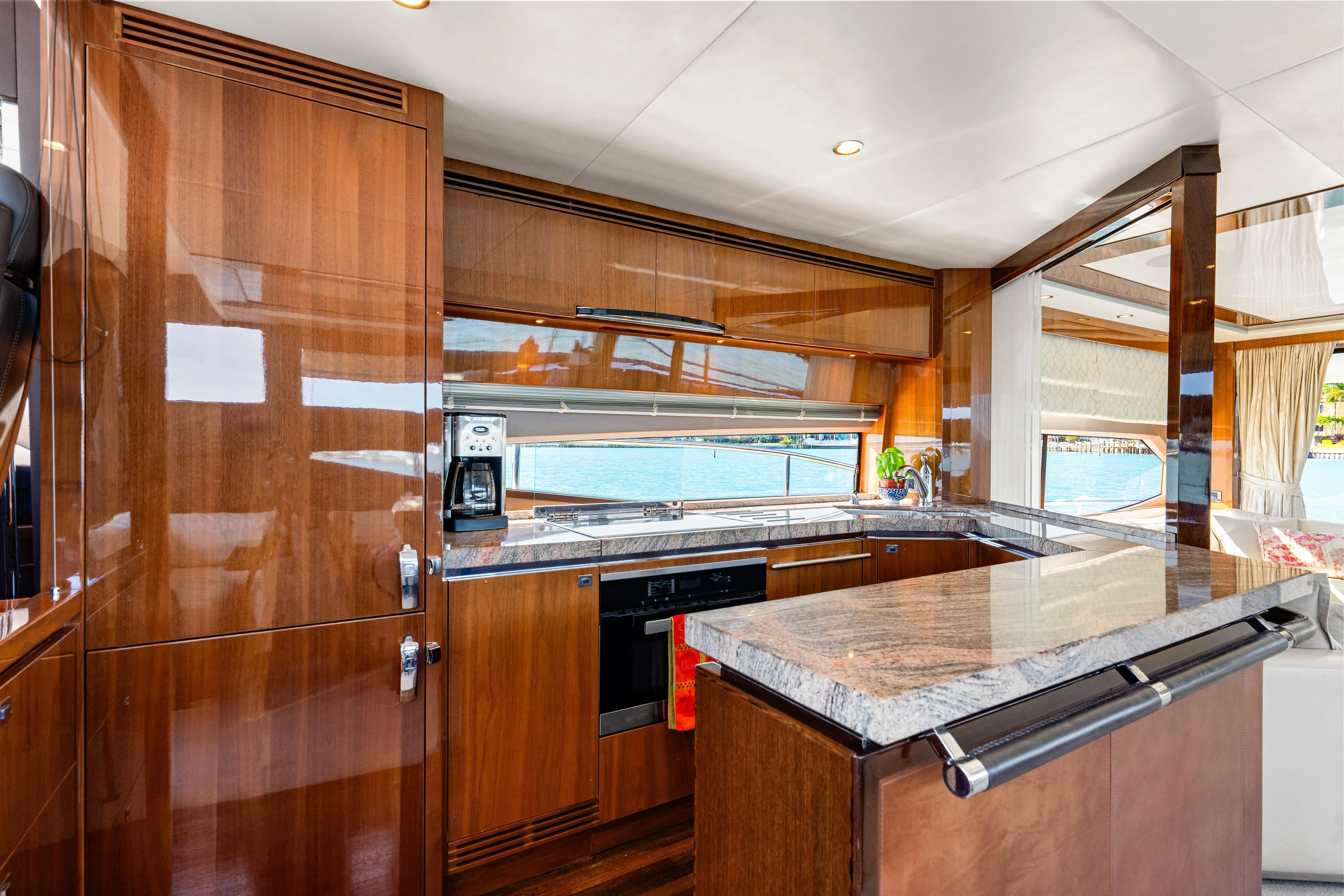 Fortunato Yacht Photos Pics Luxurious kitchen interior on 2014 Princess Y72 yacht with wood cabinetry and granite countertops.