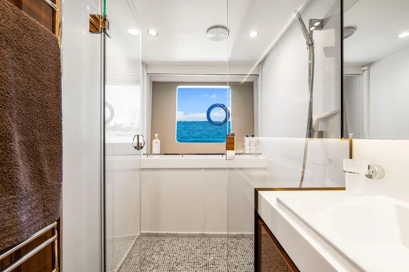 Fortunato Yacht Photos Pics Luxurious bathroom on 2014 Princess Y72 yacht with ocean view through porthole.