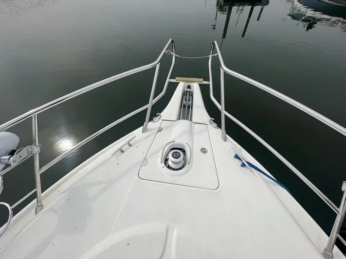  Yacht Photos Pics Bow view of 2004 Cranchi Atlantique 48 yacht, featuring sleek railings and calm waters.