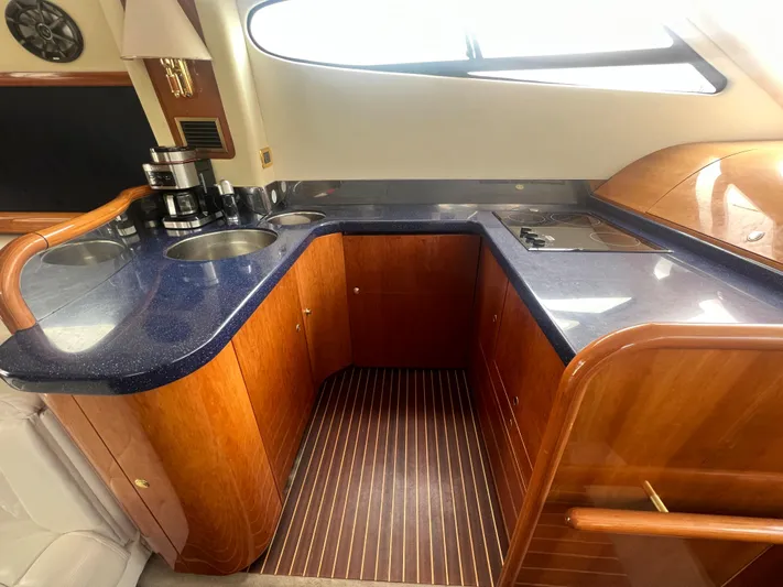  Yacht Photos Pics Luxurious kitchen area in 2004 Cranchi Atlantique 48 yacht with wood cabinetry and modern appliances.