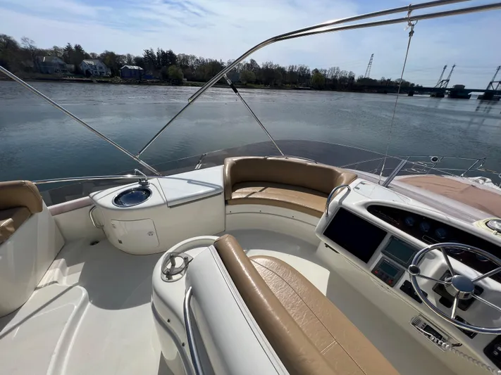 Yacht Photos Pics 2004 Cranchi Atlantique 48 yacht cockpit with leather seating, steering wheel, and water view.