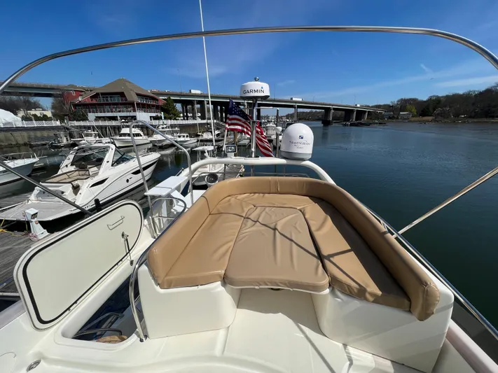 Yacht Photos Pics 2004 Cranchi Atlantique 48 yacht with tan seating, docked by a calm river.