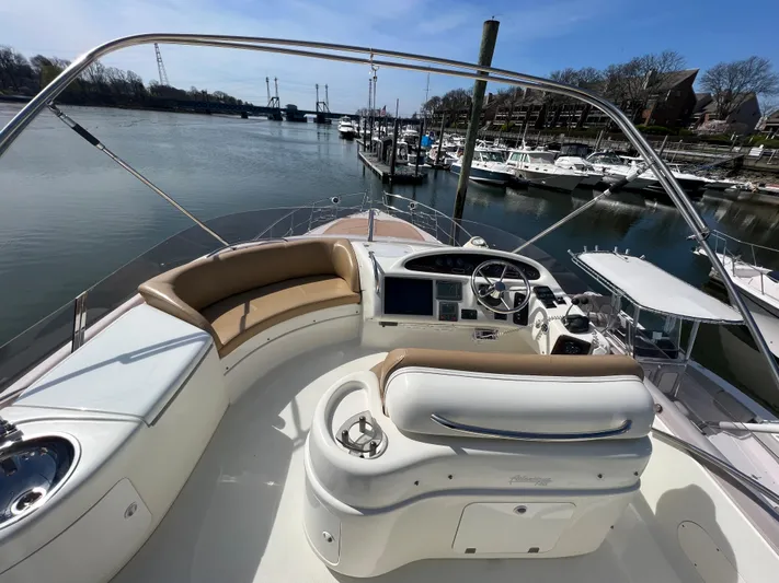  Yacht Photos Pics 2004 Cranchi Atlantique 48 yacht with spacious deck and helm, docked at a marina.