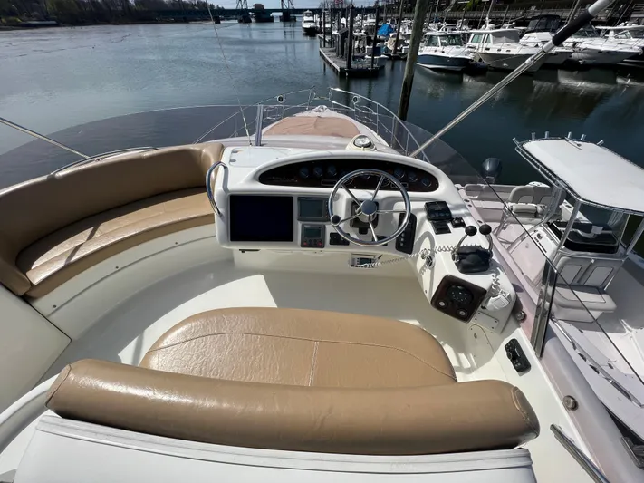  Yacht Photos Pics 2004 Cranchi Atlantique 48 yacht helm with tan seating, docked at marina.
