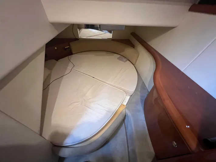 Yacht Photos Pics 2004 Cranchi Atlantique 48 cabin interior with round bed and wooden cabinetry.