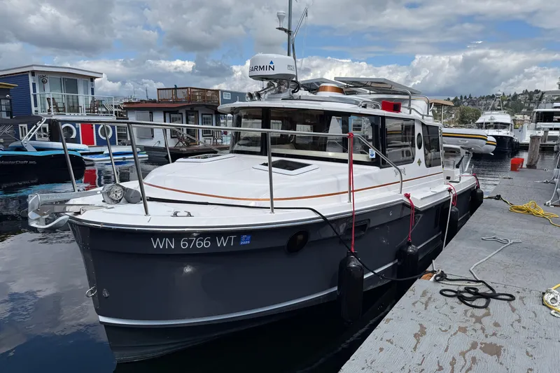  Yacht Photos Pics 2024 Ranger Tugs R-25 boat docked at marina under cloudy sky.