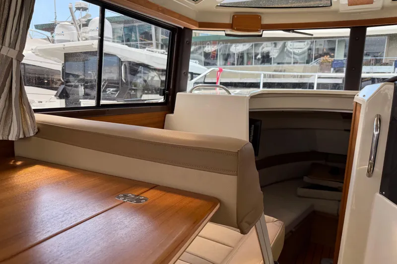  Yacht Photos Pics Interior of 2024 Ranger Tugs R-25 boat, featuring seating and wooden table.