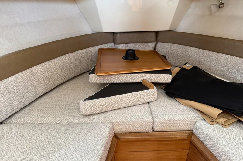  Yacht Photos Pics 2024 Ranger Tugs R-25 cabin interior with cushions and wooden table.