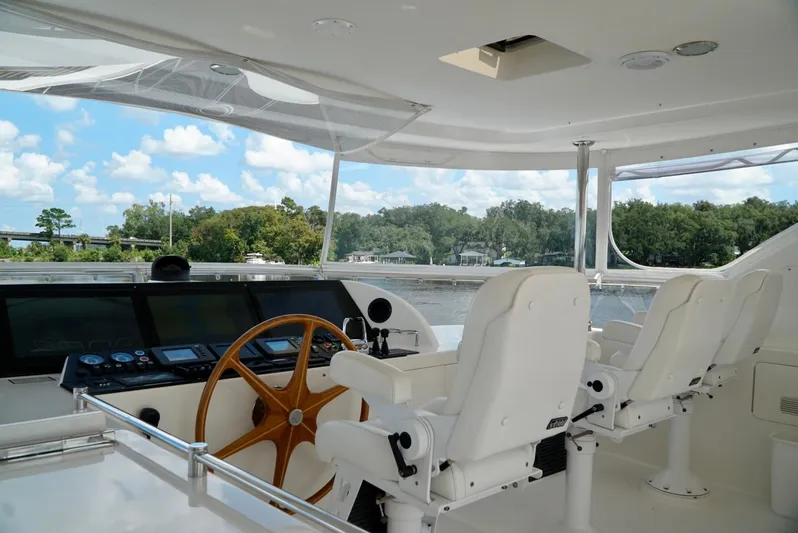Miss Patti Yacht Photos Pics 2008 Ocean Alexander 74 Motoryacht helm with white seating and wooden steering wheel.