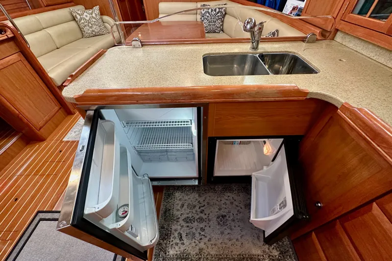 Dasananas Yacht Photos Pics Luxurious 2008 Hunter 49 yacht interior with open fridge, sink, and seating area.