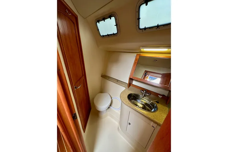 Dasananas Yacht Photos Pics 2008 Hunter 49 yacht bathroom with sink, toilet, and wooden cabinetry.