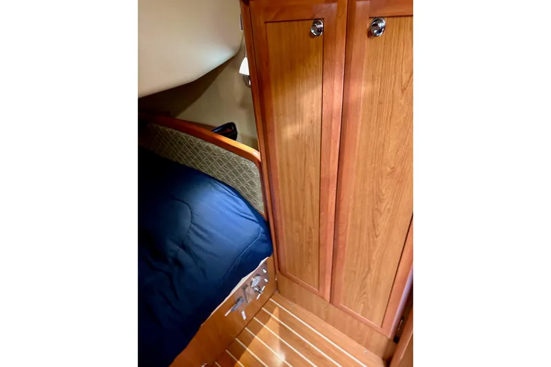 Dasananas Yacht Photos Pics Cozy cabin interior of 2008 Hunter 49 sailboat with wooden cabinetry and blue bedding.