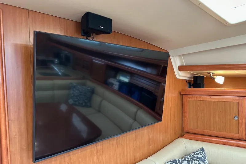 Dasananas Yacht Photos Pics Flat-screen TV and speaker in 2008 Hunter 49 yacht interior with wood paneling.