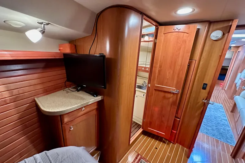 Dasananas Yacht Photos Pics Interior of 2008 Hunter 49 yacht with wood paneling, TV, and compact bathroom.