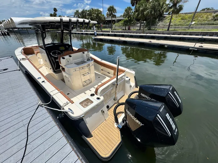  Yacht Photos Pics 2024 Scout 277 LXF boat docked with dual Mercury engines, sleek design, and spacious deck.